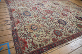 Corner of an Antique Mahal carpet featuring ivory field, scrolling terra cotta vinery, and a geometric border.