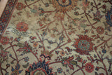 Close-up of antique Mahal carpet, terra cotta vinery and lotus flowers on sand with threadbare pile.