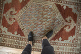 Distressed Malayer rug featuring slate blue boteh lattice and faded chestnut geometric borders.