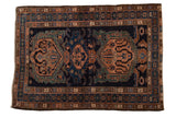 Vintage Malayer rug with a triple oversize medallion in brown and dusty green on a navy blue field.