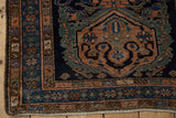 Corner of a vintage Malayer rug with intricate borders and an intact side cord selvage.