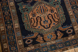 Fine geometric borders of a vintage Malayer rug in dusty green and coffee brown on a navy field.