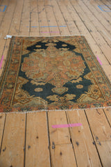 Vintage distressed Malayer rug corner, showing secured fringe and side with dusty rose field.