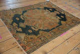 Distressed vintage Malayer rug corner, featuring dusty navy, rose field, and textural wear to knot heads.
