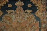 Distressed texture and simplistic floral designs on a dusty rose and navy Malayer rug.