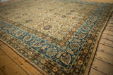 Distressed vintage Meshed rug corner, with ornate blue border and textured floral field.
