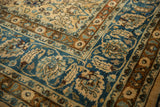 Distressed Meshed rug corner, intricate floral vinery borders in camel, sky blue, and copper.