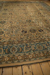 Intricate blue and camel floral border of a distressed vintage Meshed rug with visible worn edge.