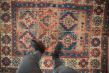 Antique Caucasian rug displaying geometric Moghan medallions with visible foundation and soft patina.