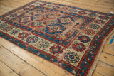 Geometric Moghan ram's horn motifs in sapphire blue, cherry red, and ivory with worn pile.