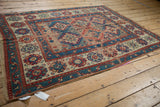 Antique Caucasian rug corner, showing geometric ram's horn medallions and floral border.