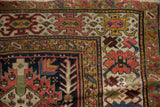 Kuba runner corner with serrated diamond patterns, tree-of-life, aged pile in red, ivory, and navy.