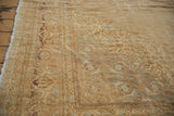 Distressed Indian Tabriz rug: ornate border detail with faded beige and copper pile.