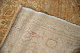 Woven foundation and distressed pile of the Indian Tabriz design rug with curled edge.
