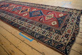 Northwest Persian runner's repeating diamond medallion with serrated details and cochineal red field.