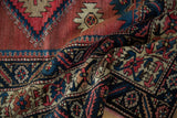 Folded pile texture of hand-knotted geometric serrated and crab motifs in indigo, cochineal red.