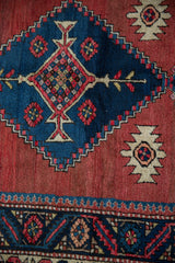Vintage Northwest Persian runner, navy blue crab style border and red serrated diamond medallion.