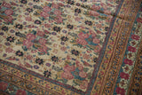 Detail of antique Kerman rug's intricately patterned border and field of cochineal golferang roses.