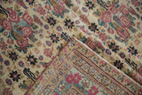 Antique Kerman runner corner with blush golferang roses, intricate borders, and visible hand-knotted foundation.