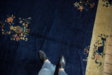 Vintage Peking carpet detail: cobalt blue field, dusty gold floral motif, foot for scale.