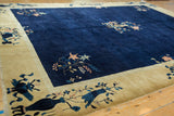Corner detail of Peking carpet, with pictorial vase motif on dusty gold border and fringe.