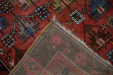Antique Caucasian carpet corner revealing hand-knotted back, dusty raspberry pile, and yellow selvage.