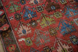 Antique Caucasian carpet detail: dusty raspberry field, blue, green floral lattice, dark border.