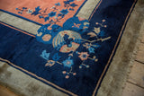 Corner detail of a vintage Peking rug with lustrous indigo blue, copper bird, and floral motifs.
