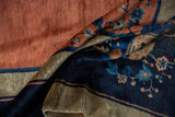 Detail of vintage Peking carpet showcasing soft, lustrous copper and indigo floral wool pile.