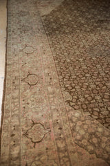 Distressed Tabriz carpet detail: coffee brown Herati motif field with a faded pale blush border.