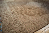 Distressed vintage Tabriz carpet corner, showcasing faded Herati motif and soft blush, ivory, coffee tones.