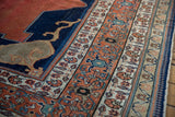 Antique Tabriz carpet: Indigo field with Samovar element, madder red and celadon geometric border.
