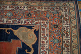 Antique Tabriz carpet corner: Indigo Samovar spandrel, madder red floral border, intact original selvage.