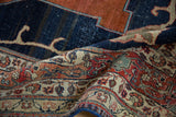 Antique Tabriz carpet's curvilinear Samovar design and floral border in madder red, indigo blue.