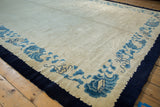 Detail of vintage Peking rug with floating indigo border and sky blue cloud motifs.