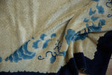 Plush ivory pile with sky blue and indigo flowing patterns on the Peking carpet.