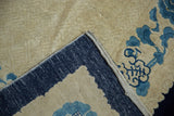 Folded corner of vintage Peking rug, showing deep blue plain weave, selvage, and ivory pile.