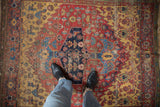 Antique Halvai Bijar rug with unique asymmetric medallion, saffron yellow spandrels, and visible wear.