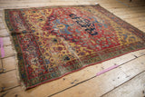 Traditional Persian Halvai Bijar: asymmetric navy medallion, saffron spandrels, and worn floral field.