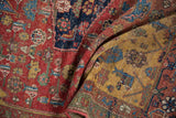 Halvai Bijar rug's cherry red field, saffron yellow spandrel, and green border with visible knot heads.