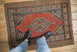 A vintage Serab rug's geometric medallion in navy and red set against a wide camel hair border.