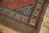 Detail of a vintage Serab rug corner with even wear, showing intricate floral and geometric borders.