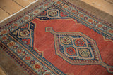 Angled view of a vintage Serab rug's corner spandrel, showing even wear and a camel hair border.