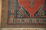 The even pile and geometric corner spandrel of a vintage hand-knotted camel hair Serab rug.