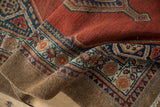 Rich texture of the brick red pile beside the natural, undyed camel hair border of a vintage Serab rug.