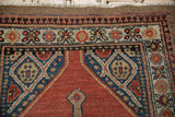 Close-up on the pomegranate floral border and even wear of a vintage camel hair Serab rug.