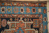 Vintage Karaja rug detail: hand-knotted geometric starbursts with abrashes in sky blue, terracotta.