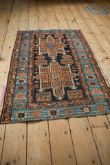 Vintage Karaja rug corner: geometric border and field patterns in navy, terracotta, sky blue.