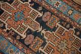 Detailed view of a hand-knotted Karaja rug with geometric terracotta, navy, and sky blue abrashes.