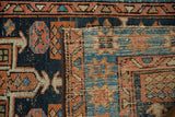 Close-up of vintage Karaja rug's hand-knotted pile in dusty navy and terracotta, contrasting with woven foundation.